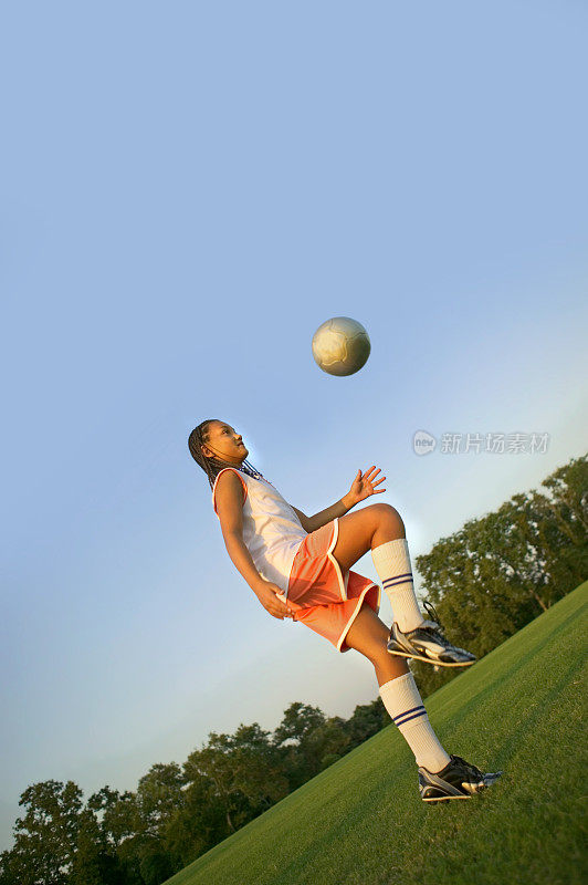 年轻女孩踢足球/足球